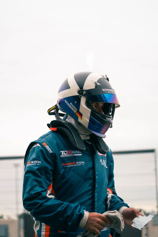 Maximilian Kochendörfer mit Helm im Rennanzug von Wimmer Werk Motorsport